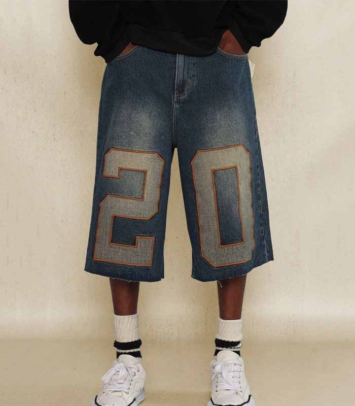 Jeans corti in denim con bordo grezzo e applicazioni