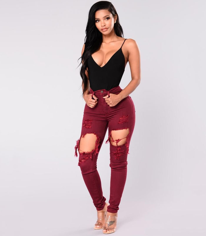 Sexy high-waisted skinny jeans in fiery red with edgy ripped details for a rebellious streetwear look."