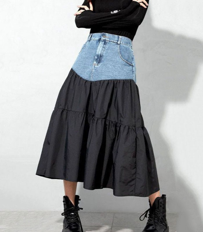 denim skirt featuring patchwork design with black woven fabric and light blue denim