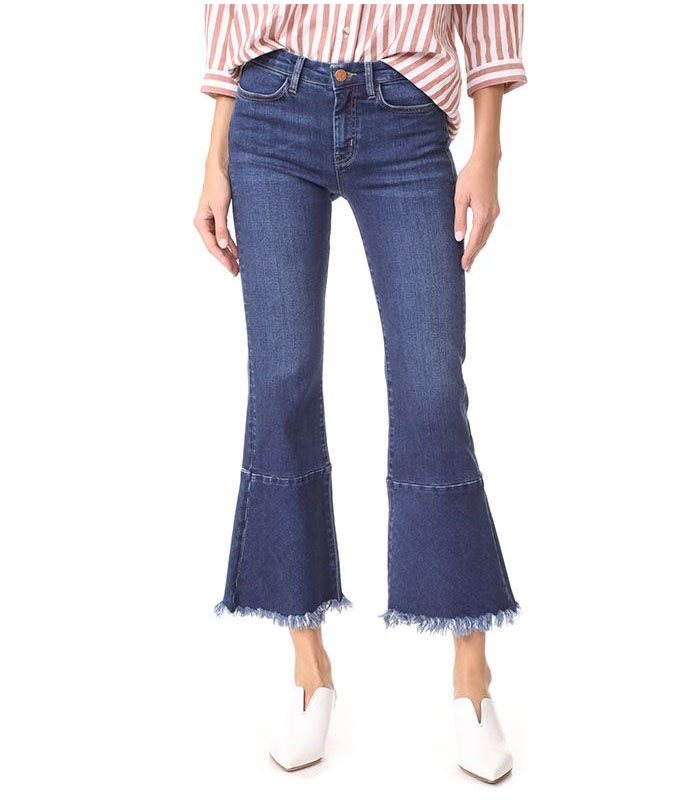 Distressed hem mid-blue flare jeans with a stylish frayed edge for women's